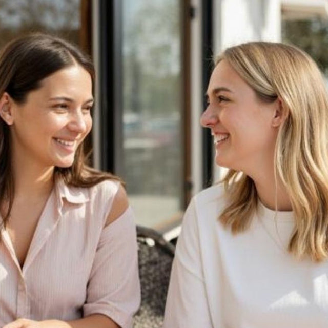 Two colleagues in an honest conversation over coffee at a sunny cafe