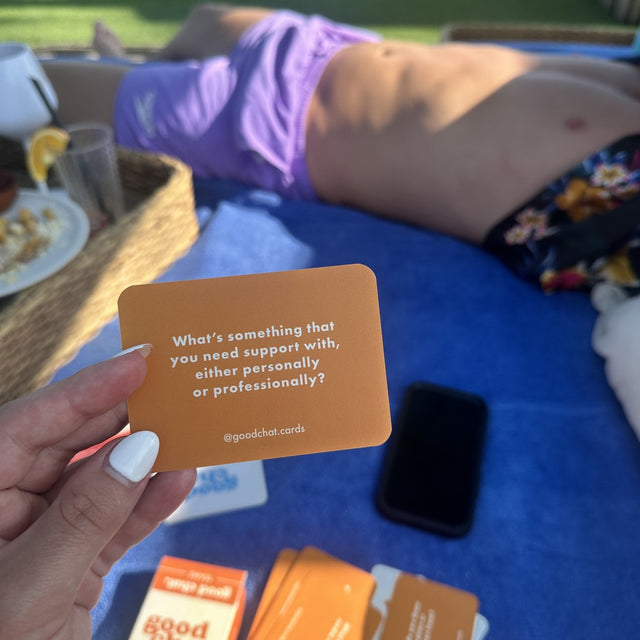 Overhead poolside shot with a hand holding an orange Teams card in bright sun
